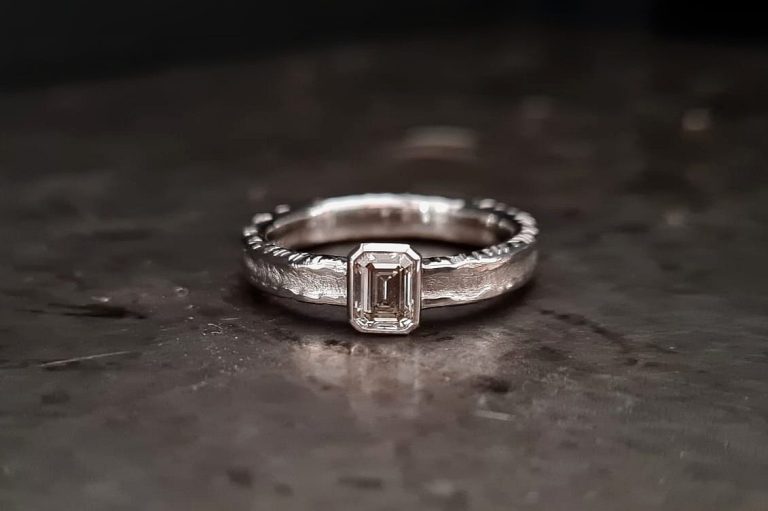 Silberring mit strukturierter Oberfläche kombiniert mit einem Weißgoldring den ein hellblauer Saphir ziert