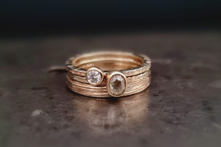 gestapelte Goldringe besetzt mit weißem und naturgetönten Diamant